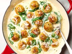 a pan filled with meatballs covered in sauce and garnished with spinach