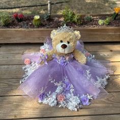 a teddy bear dressed in a purple dress