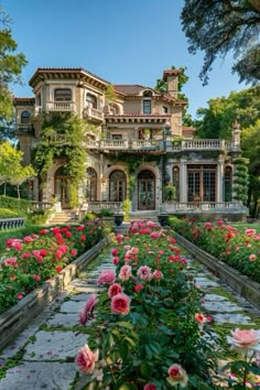 a large house with lots of flowers in front of it