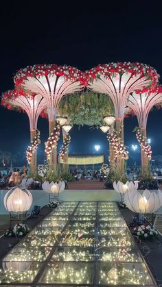 an outdoor wedding venue decorated with flowers and lights