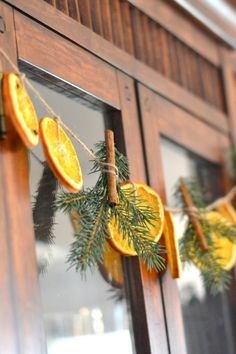 orange slices and cinnamon sticks are hung on a string with pine cones, twined together