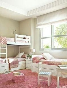 a room with bunk beds and pink rugs on the floor in front of a window