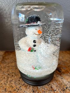 a snowman in a glass jar with bubbles