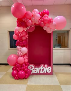 pink balloon arch in the shape of a barbie's name sign with balloons on it