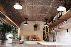 the interior of a restaurant with lots of counter space and lights hanging from the ceiling