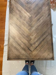 a person standing on top of a wooden floor next to a piece of wood that has been cut in half