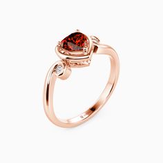 a rose gold ring with a heart shaped garnet stone and two diamonds on the side