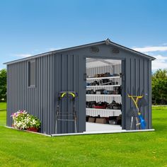 a shed with the door open and gardening tools in it on top of green grass