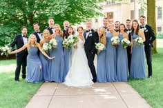 a group of people standing next to each other in front of a building with trees