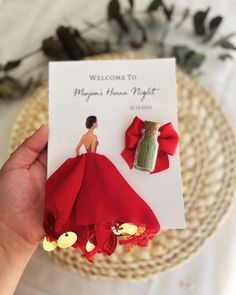 a person holding up a card with a red dress on it