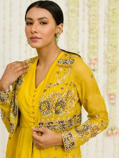 Editor's Note Mustard Hand Embroidered Jacket With Matching Peplum And Sharara In Crepe Fabric: Crepe, Organaza Color: Mustard Care: Dry Clean Only About the Designer Sanya Gulati's designs are inspired by the Indian bridesmaids, pastel easy hues & seasonal trends, her designs are a mix of modern, contemporary embroideries with traditional silhouettes thus creating our signature asymmetric checks embroideries amalgamated with floral thread work, through her designs, the designer aims to enhance Yellow Long Sleeve Top With Resham Embroidery, Festive Embellished Long Sleeve Sets, Festive Long Sleeve Embellished Sets, Embellished Anarkali Kurta With Long Sleeves, Yellow Kurta With Floral Embroidery And Long Sleeves, Yellow Long Sleeve Kurta With Floral Embroidery, Yellow Long Sleeve Top With Chikankari Embroidery, Yellow Long Sleeve Blouse With Resham Embroidery, Festive Yellow Long Sleeve Tops