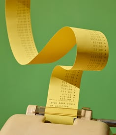 a roll of yellow tape is sticking out of an old typewriter