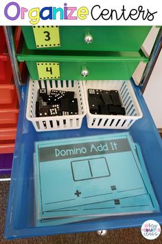 an organized classroom area with dominos and numbers on the tray in front of it