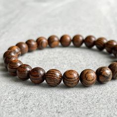 Features: ~ 6mm, 8mm or 10mm fragrant Tiger Skin Sandalwood beads ~ Strong, non-fraying elastic cord; simply slide bracelet on and off wrist ~ Comes packaged in a re-usable microfiber pouch ~ Avoid wearing in water as wood naturally fades if exposed to water To ensure the perfect fit, please use the bracelet sizing instructions found in the photo gallery. For more wood beaded bracelets please use the following link: https://www.etsy.com/ca/shop/FujiBeads?ref=shop_sugg&search_query=wood Be sure t Wooden Bead Bracelet, Tiger Skin, Slide Bracelet, Wood Bead Bracelet, Mens Beaded Bracelets, Bead Bracelet, Grosgrain Ribbon, Bracelet Gift, Wooden Beads