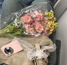 flowers are wrapped in plastic and placed on the back of a car seat with a camera