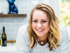 a woman sitting at a kitchen counter smiling