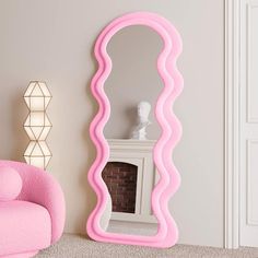 a large pink mirror sitting next to a chair in a living room on top of a carpeted floor