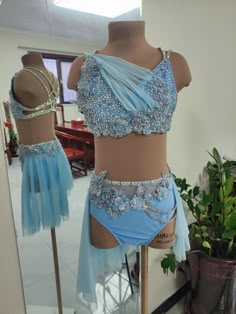 two mannequins are dressed up in blue and silver outfits with beading on them