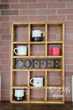 a wooden shelf with coffee cups and mugs on it in front of a brick wall