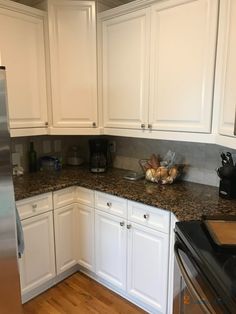 a kitchen with white cabinets and granite counter tops