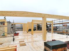 an unfinished building with wooden beams and scaffolding on the roof, along with other construction materials