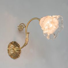 a wall light that is attached to the side of a wall with a flower on it