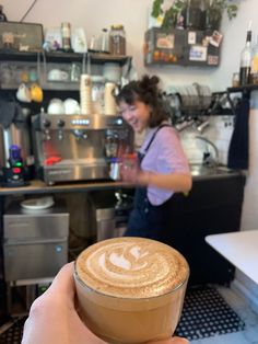 a person holding up a cup of coffee