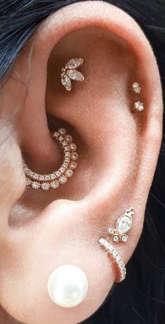 an ear with three different types of piercings