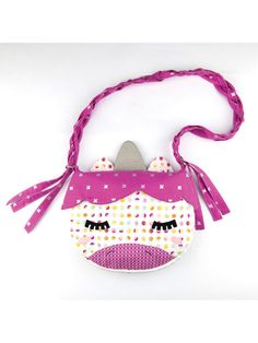 a pink purse with an animal face on it's side and a purple ribbon around the neck