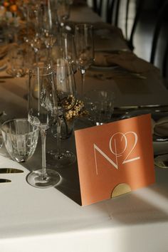 the table is set with wine glasses and place cards