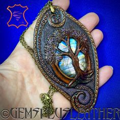 "\"Yggdrasil\" is a hand tooled and hand painted leather tree of life pendant with rainbow labradorite cabochon. An exclusive gift for a special one ❤️ This OOAK pendant was MADE TO ORDER, thus in not available. If you would like me to make something for you please contact me for a custom order and we'll discuss the details. I've got plenty of different cabochons in stock, thus I believe we would find something just for you. Please bear in mind I can't repeat the same precise design since each i Artisan Hand-tooled Necklace For Gift, Unique Tree Of Life Jewelry Gift, Mystical Carved Jewelry Gift, Labradorite Jewelry Gift, Brown Labradorite Jewelry For Gift, Gift Brown Labradorite Jewelry, Bohemian Labradorite Collectible Jewelry, Handmade Brown Labradorite Jewelry, Unique Hand-tooled Jewelry Gift