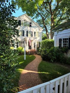 a white house surrounded by trees and bushes