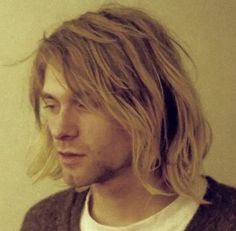 a man with long blonde hair and a white t - shirt