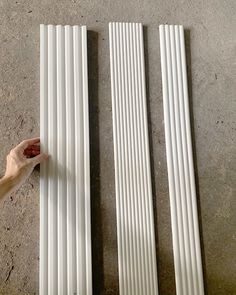 two white radiators laying on the ground with one hand reaching for something in front of them