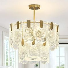 a chandelier hanging from the ceiling in a room with white walls and windows