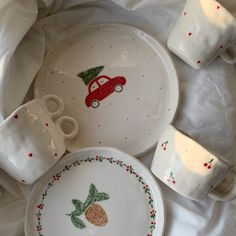 the dishes have pineapples on them and are decorated with red car designs,