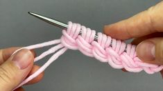 someone crocheting the end of a piece of pink yarn