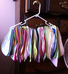 multicolored cloths are hanging on a clothes hanger in front of a dresser