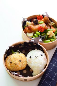 two bowls filled with rice and vegetables on top of a white table next to chopsticks