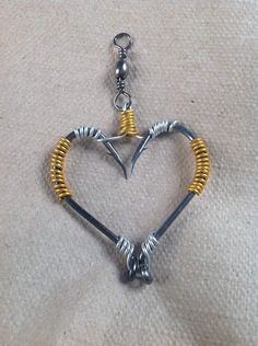 a heart shaped keychain with two gold and silver beads on it's sides