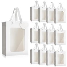 white paper bags are lined up against each other with tags attached to the handles and sides