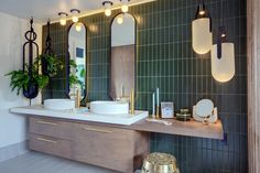 a bathroom with two sinks, mirrors and lights on the wall next to each other