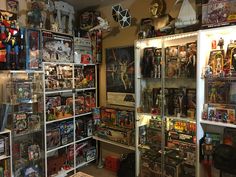 a room filled with lots of different types of action figures and games on shelves next to each other