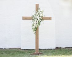 This beautiful, hand-made, cedar cross is the perfect addition for any outdoor or indoor wedding. We added beautiful white playa blanca roses, white ranunculus, ivory spray roses, ivory veronica, and sage eucalyptus, with touches of clematis draping down the sides.  The flowers shown come with the arch, unless requeste Rustic Cross Wedding Alter, Wedding Arch With White Roses, White Flowers On Cross Wedding, Floral On Cross Wedding, Flowers On Wooden Cross Wedding, Ceremony Cross Wedding, Wedding Cross Ceremony, Cross With White Flowers, Beach Wedding Cross Altar