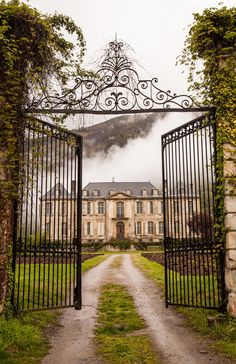 an iron gate leading to a large house