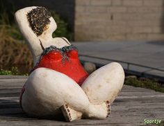 a white and red stuffed animal sitting on top of a wooden floor