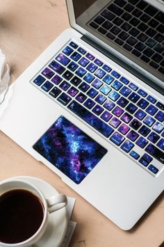 two laptops sitting next to each other on a table with coffee in front of them