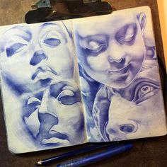 an open notebook with drawings of faces on it and a pen resting next to it