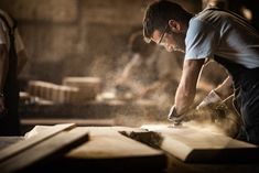 a man working with wood in a workshop