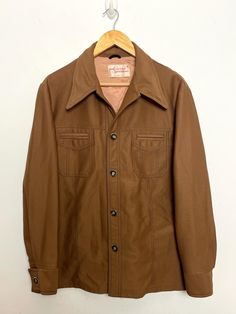 This shirt remains in pre owned condition. Measurements Pit to pit: 23 inches  Top to bottom: 28 inches Brown Shirt With Lapel Collar And Button Closure, Retro Brown Workwear Shirt, Vintage Brown Shirt For Workwear, Retro Brown Shirt With Pockets, Vintage Fitted Shirt With Pockets, Retro Fall Shirt With Pockets, Vintage Shirt With Spread Collar For Fall, Vintage Brown Shirt With Snap Buttons, Vintage Fall Shirt With Pockets